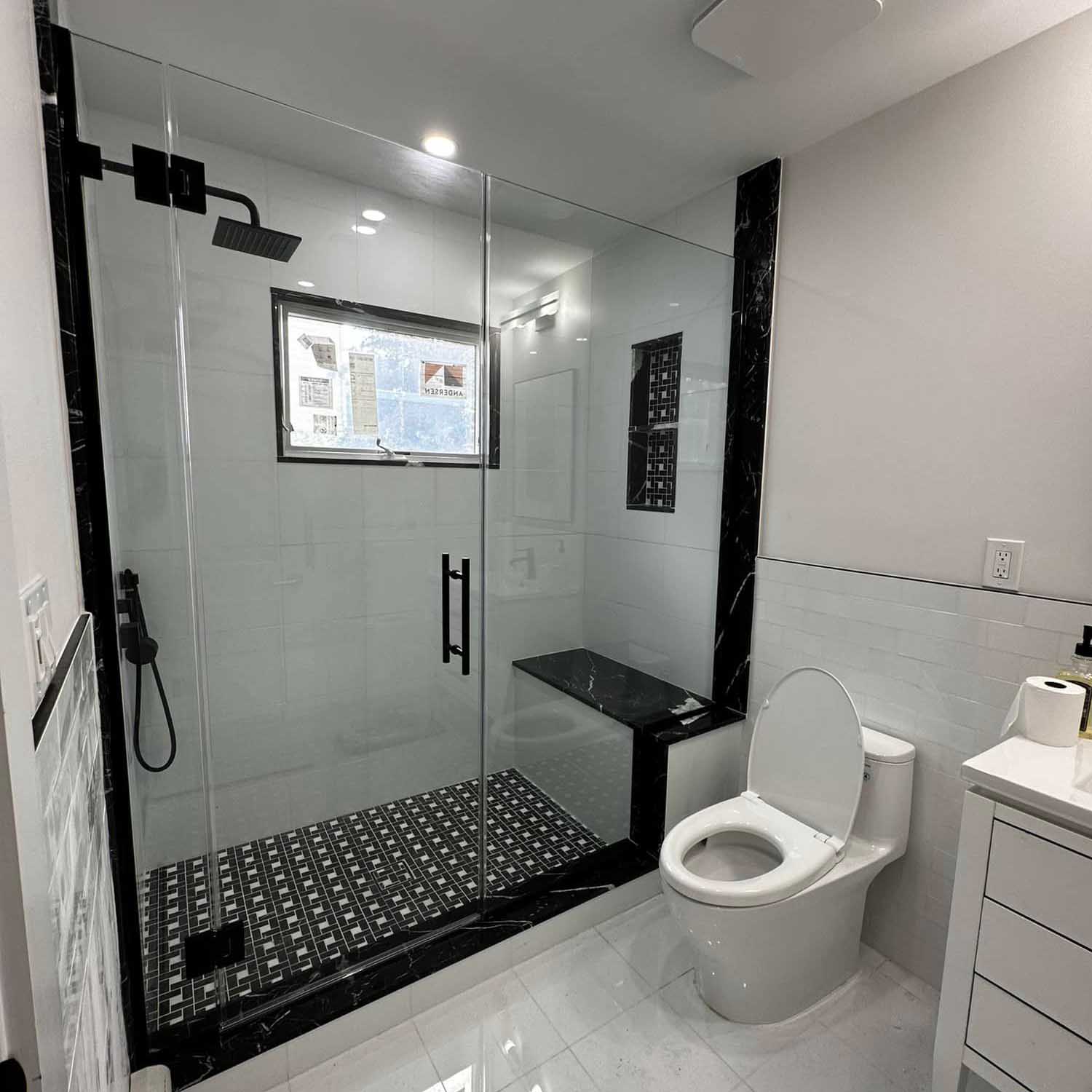 sleek black and white residential bathroom Elite Design Contracting Inc