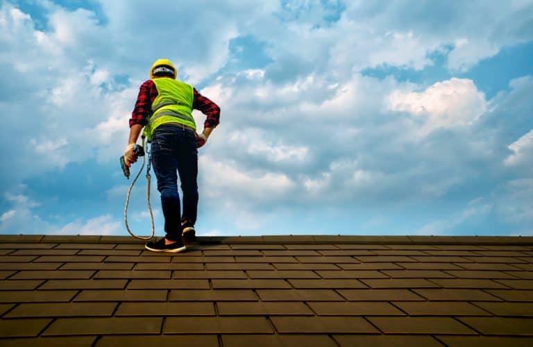 worker on roof Elite Design Contracting Inc